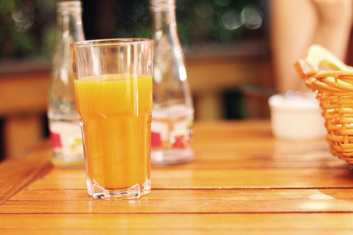 Glass of orange juice on a table.