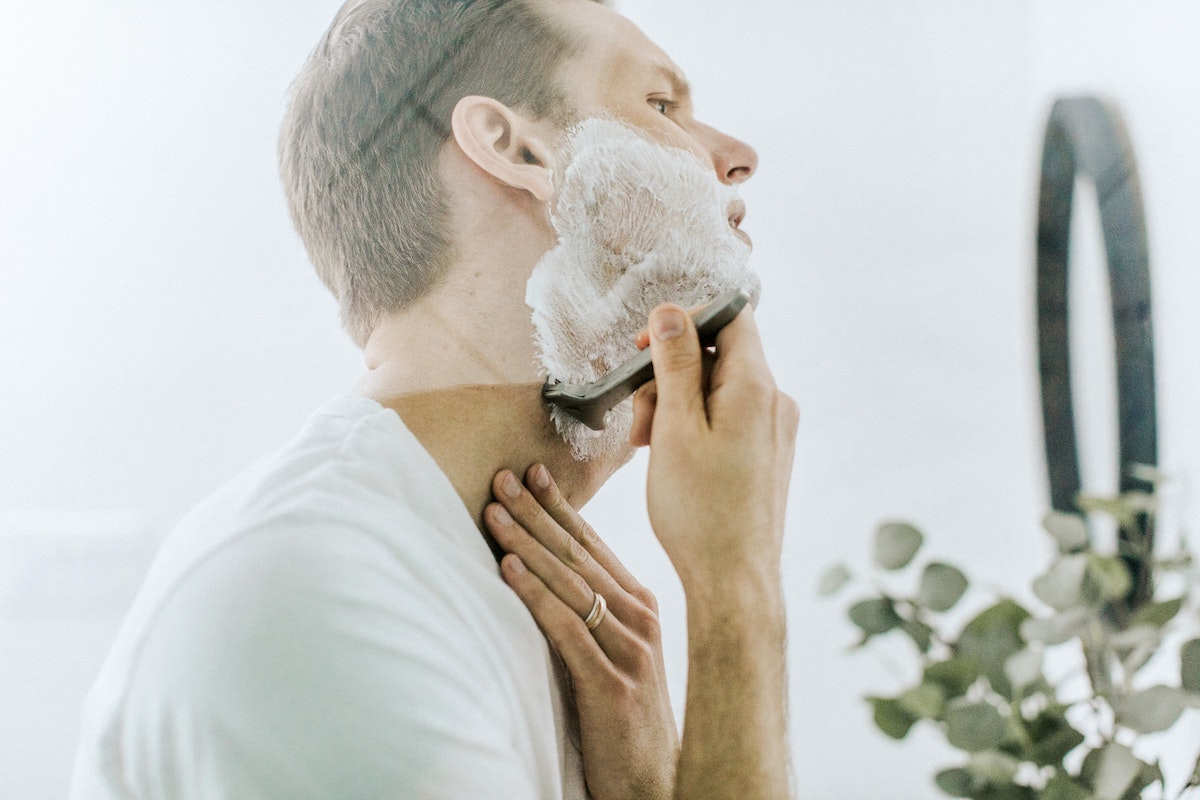 man shaving face with razor burn.