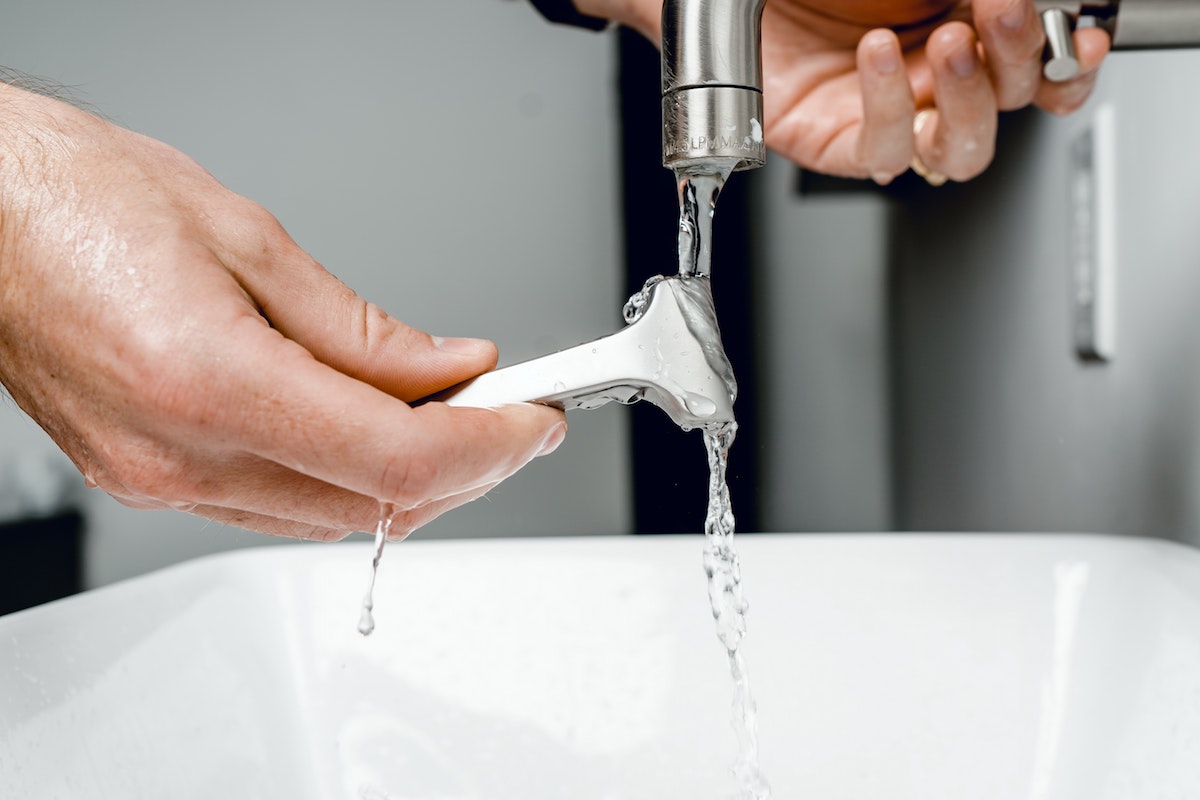 Rinsing off a razor in a sink.