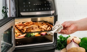 The Bella Pro Series air fryer oven with fries and vegetables being cooked.