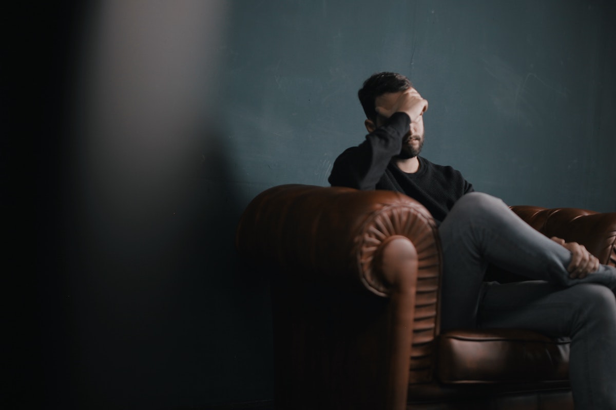 Man rubbing his temples with a migraine.