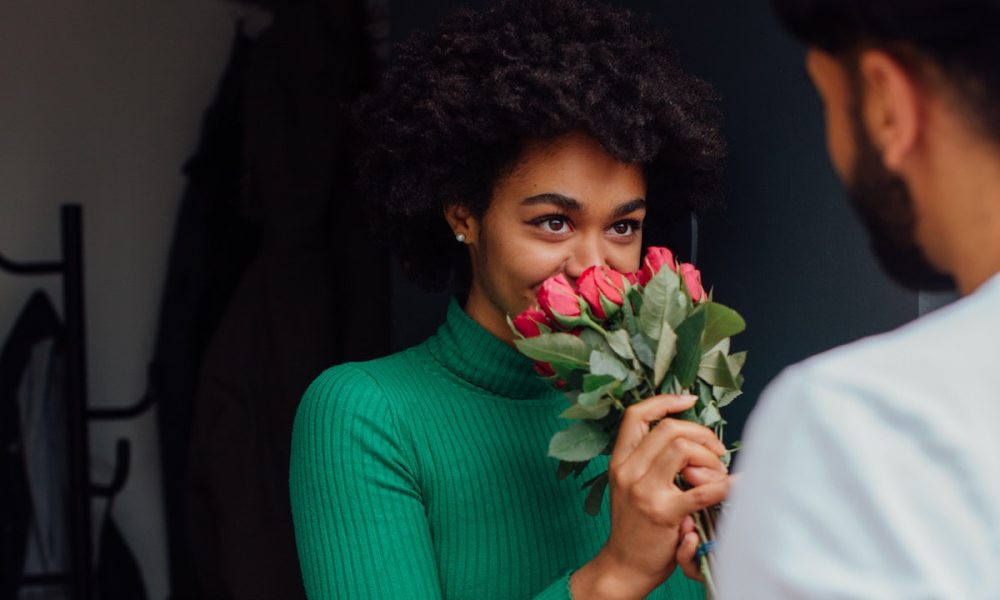 Man giving woman a bouquet of roses.