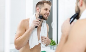 Man grooming and trimming his facial hair with a beard trimmer