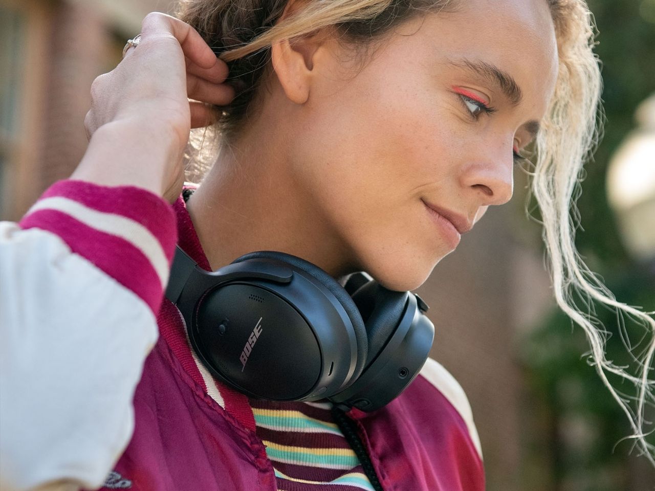 Woman wearing Bose QuietComfort 45 headphones around her neck.