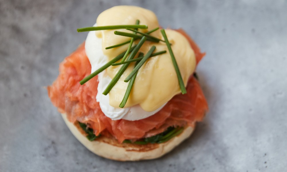 One smoked salmon eggs Benedict from queensyard on a gray blue plate.