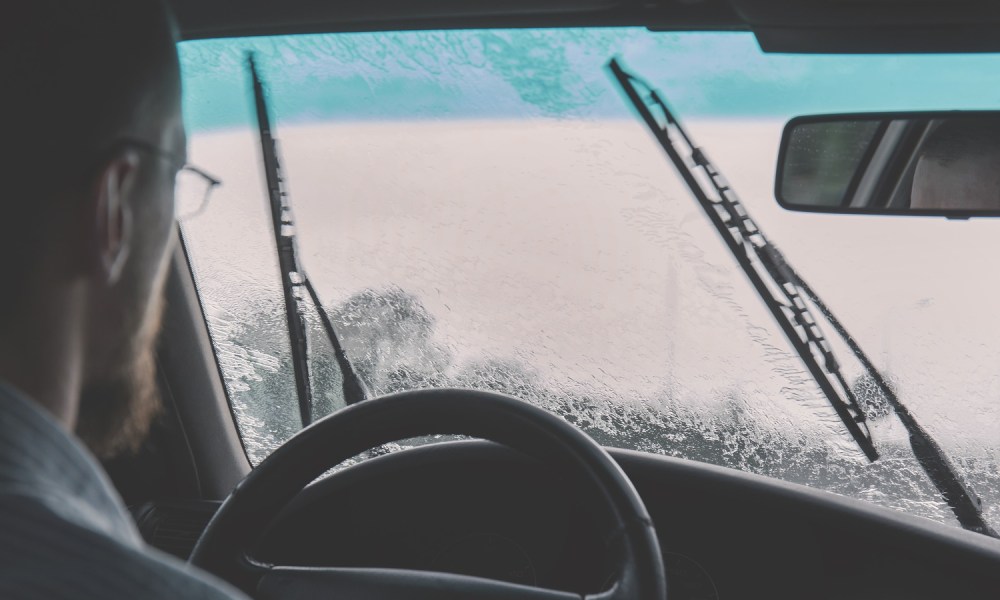 Man driving in the rain using windshield wipers.