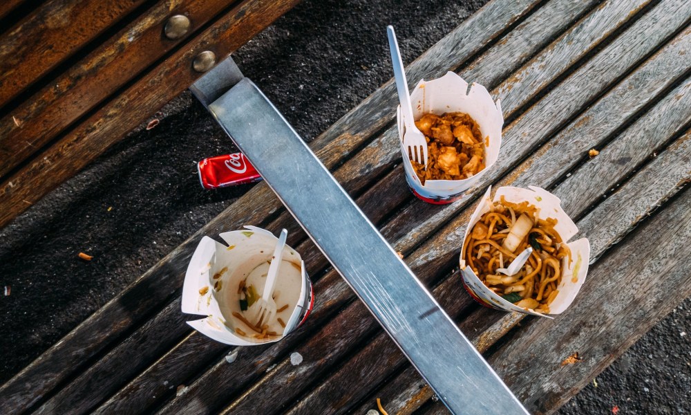 Chinese food leftovers on a wooden bench.