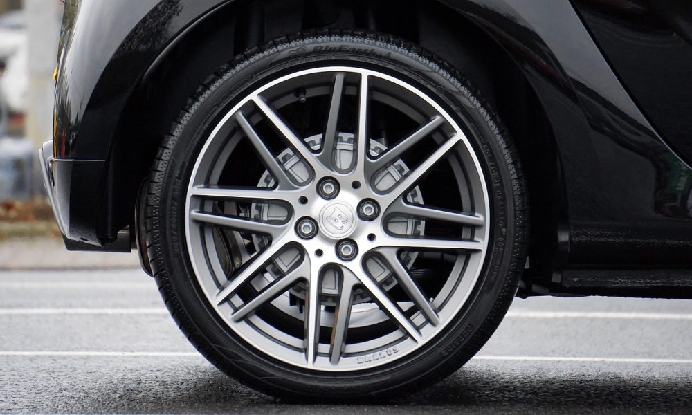 Close-up of shiny car tire with Brabus wheels on pavement.