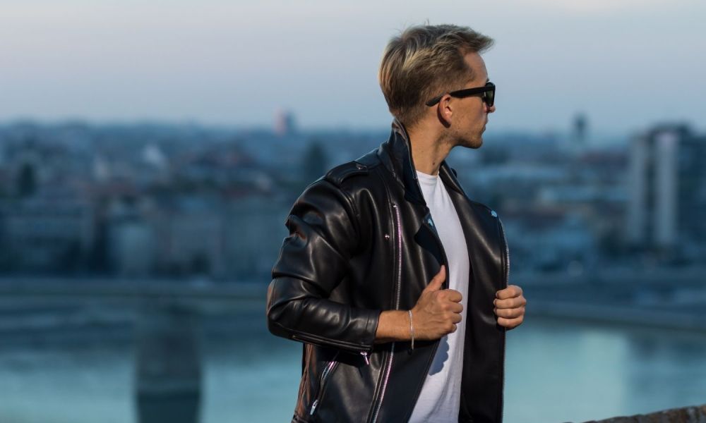 Man in leather jacket with cityscape in background