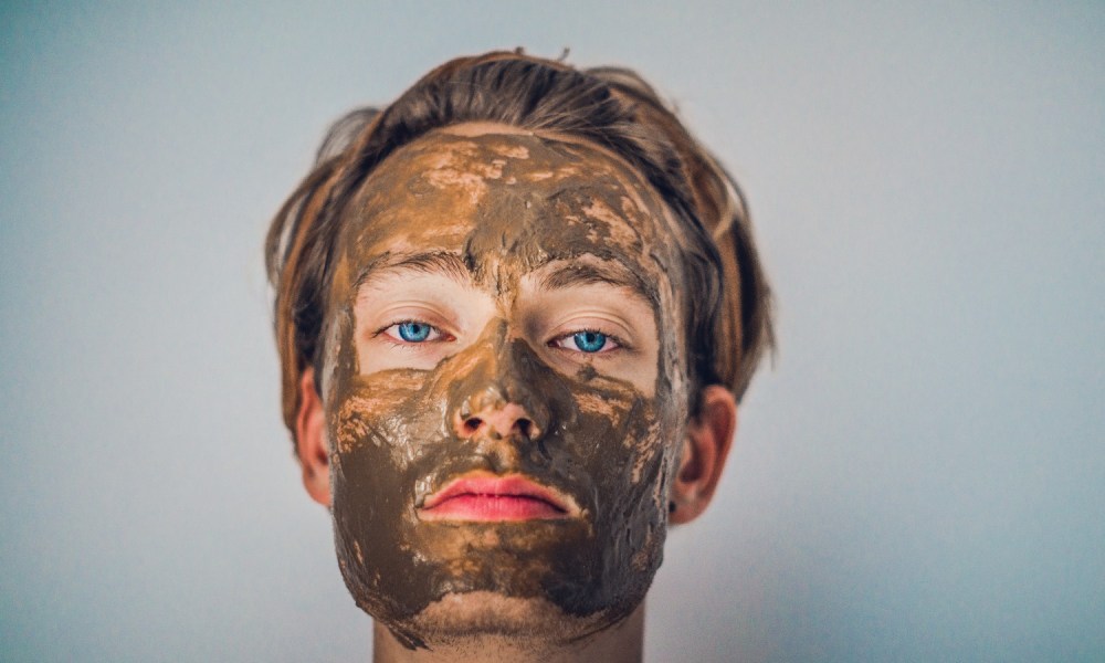 A man uses a skincare face mask.