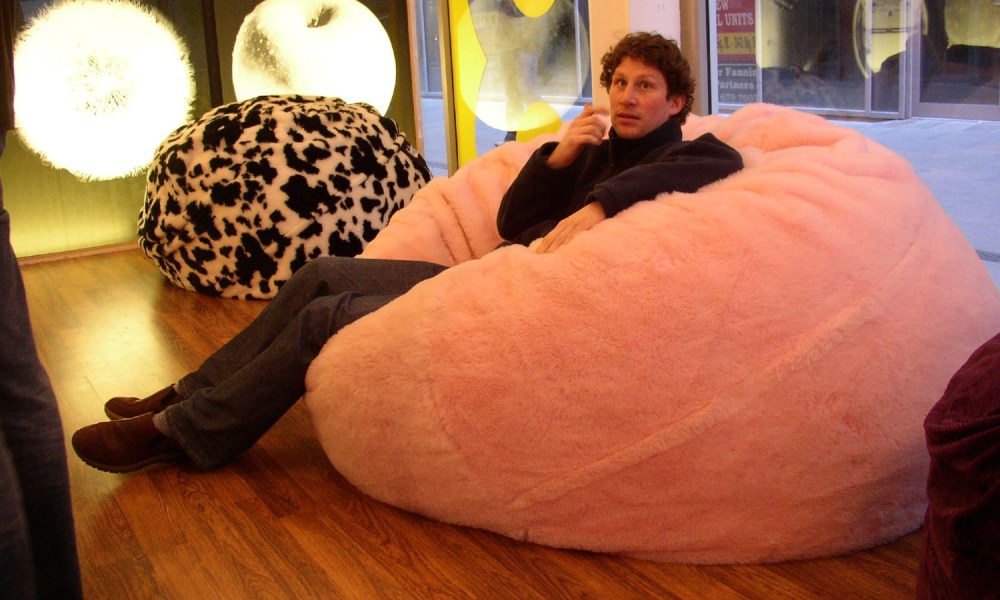 A man sits on a bean bag chair.