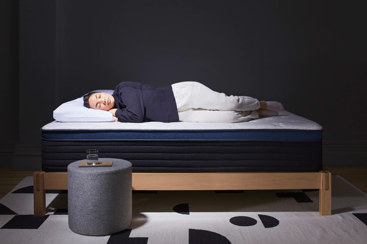 A woman sleeping on the Helix Midnight Luxe memory foam mattress.