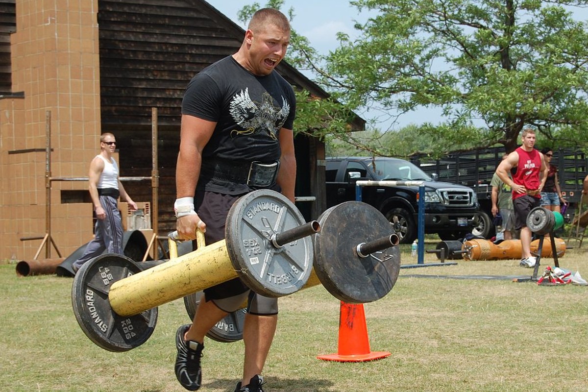 A man performing a farmer's walk at the Jack Katz Memorial Strong Man Competition.