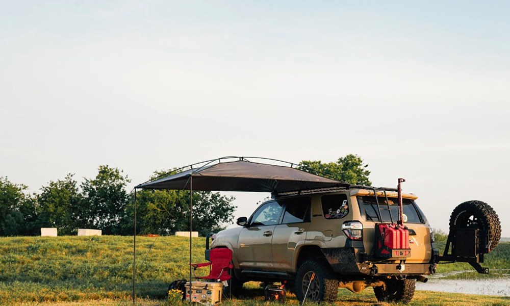 MoonShade portable vehicle awning mounted on a 4Runner near a pond.