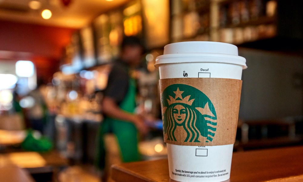 A Starbucks cup sitting on a counter inside of a store