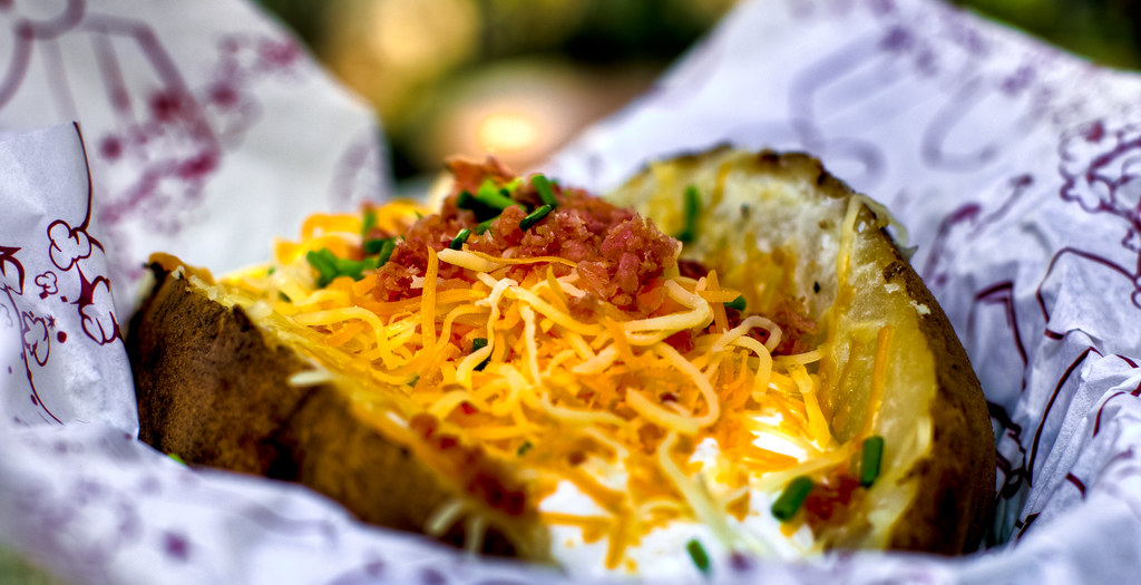 baked potato with sour cream, cheese, chives, and bacon bits