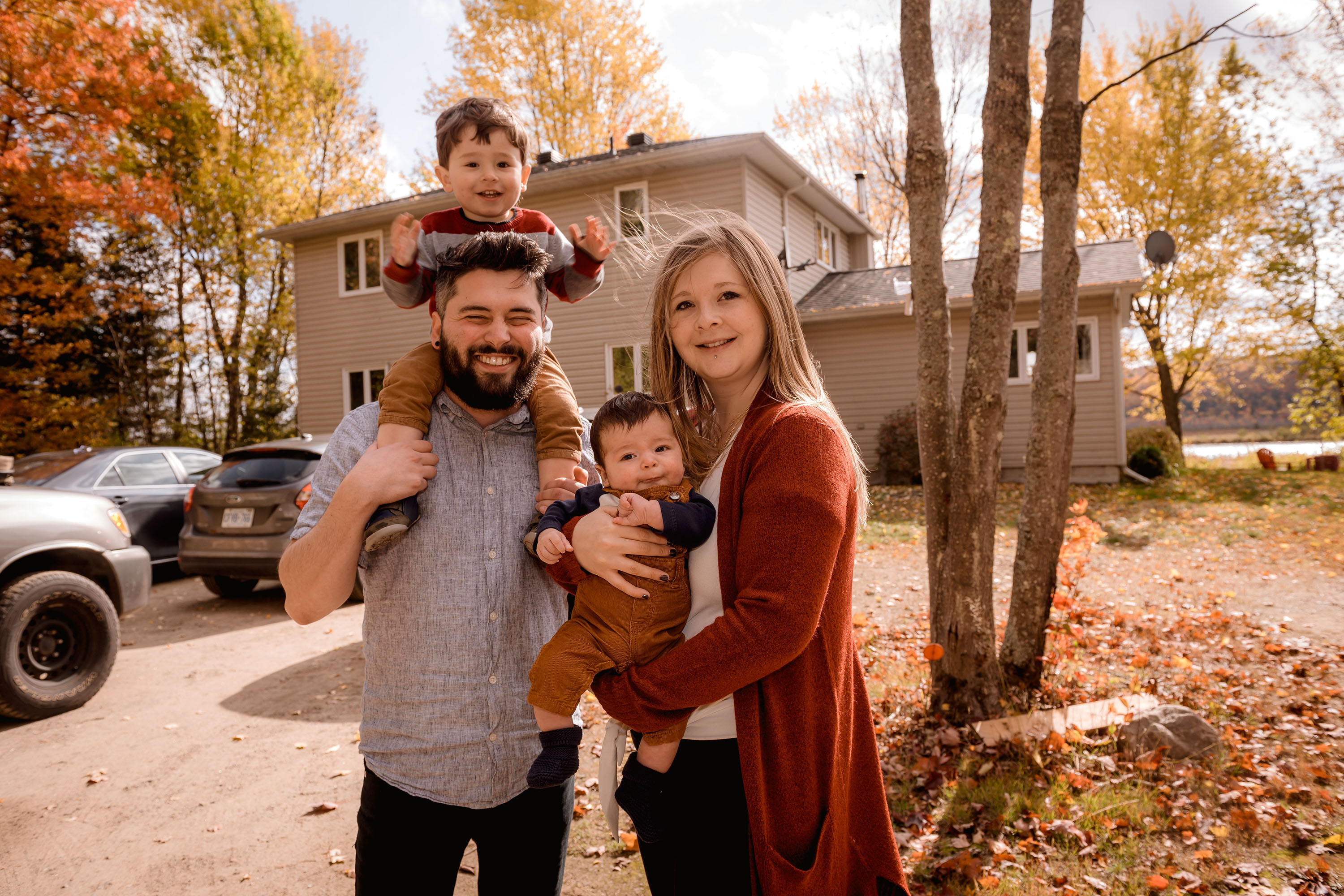 Middle class family posing outside of house