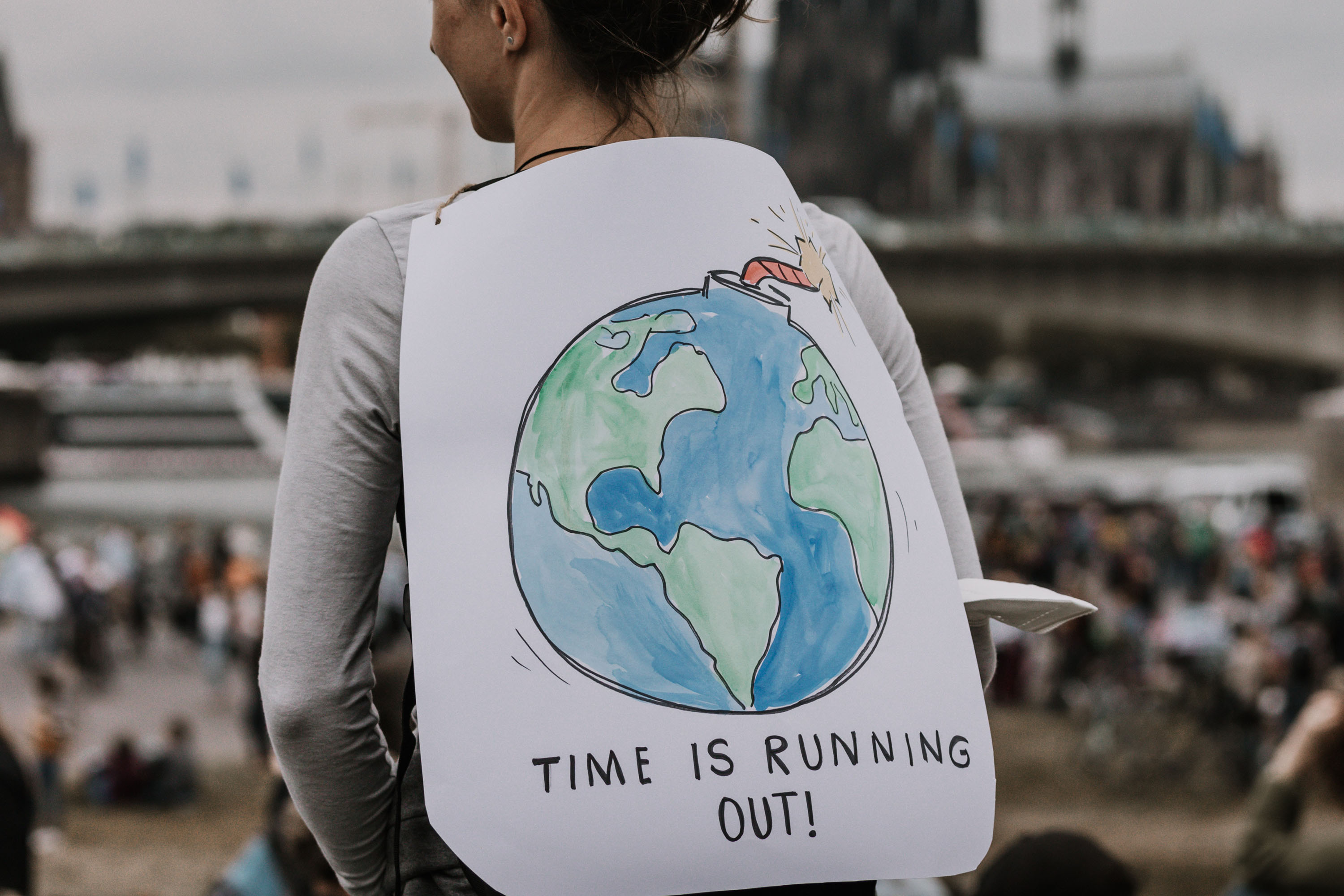 Woman at climate change protest with sign that says time is running out