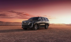 2023 Cadillac Escalade on a dirt mountain with the sun setting in the back.