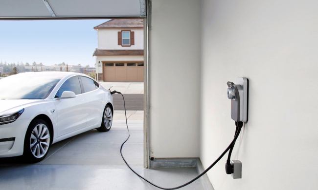 ChargePoint Home Flex EV charging station charging a white Tesla in a garage.