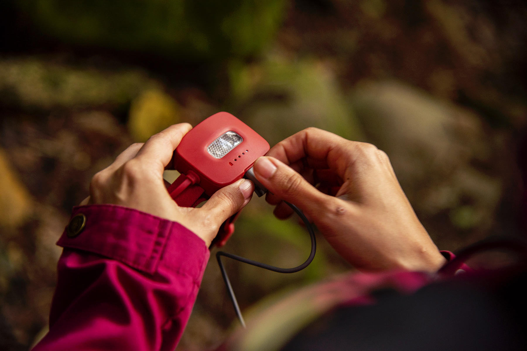 Plugging a charging unit into the rear of the BioLite HeadLamp 425