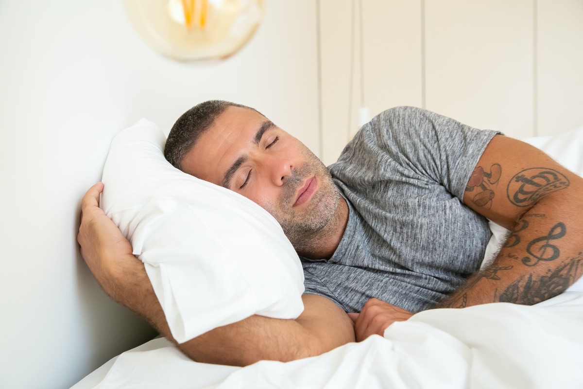 a man sleeping on white bedding