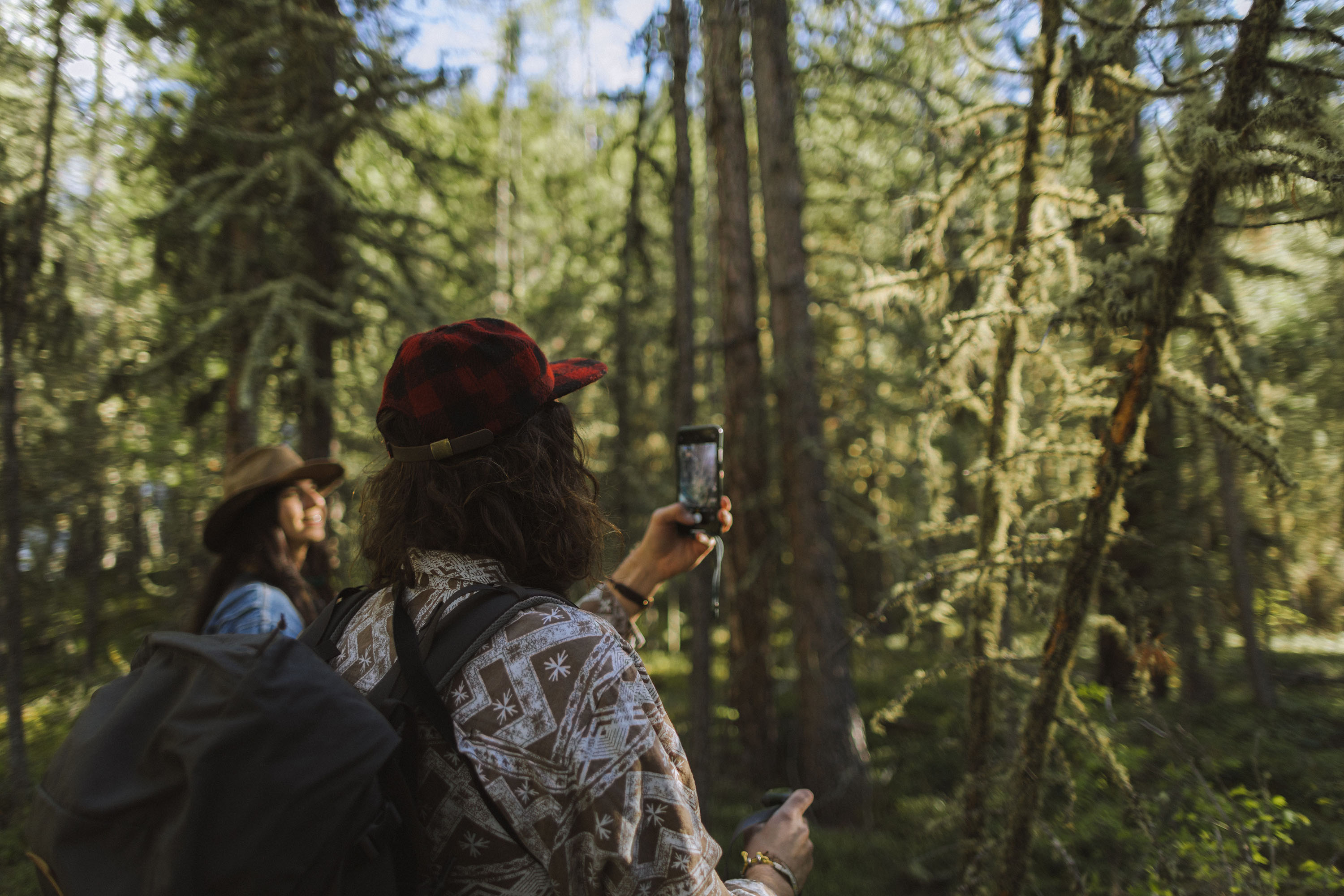 couple hiking in the woods and taking photos