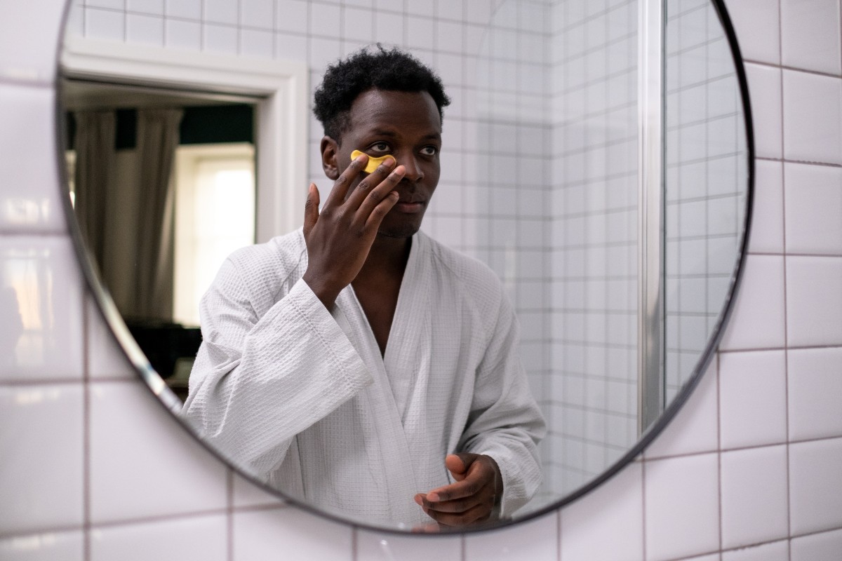 a man in a robe in front of a mirror