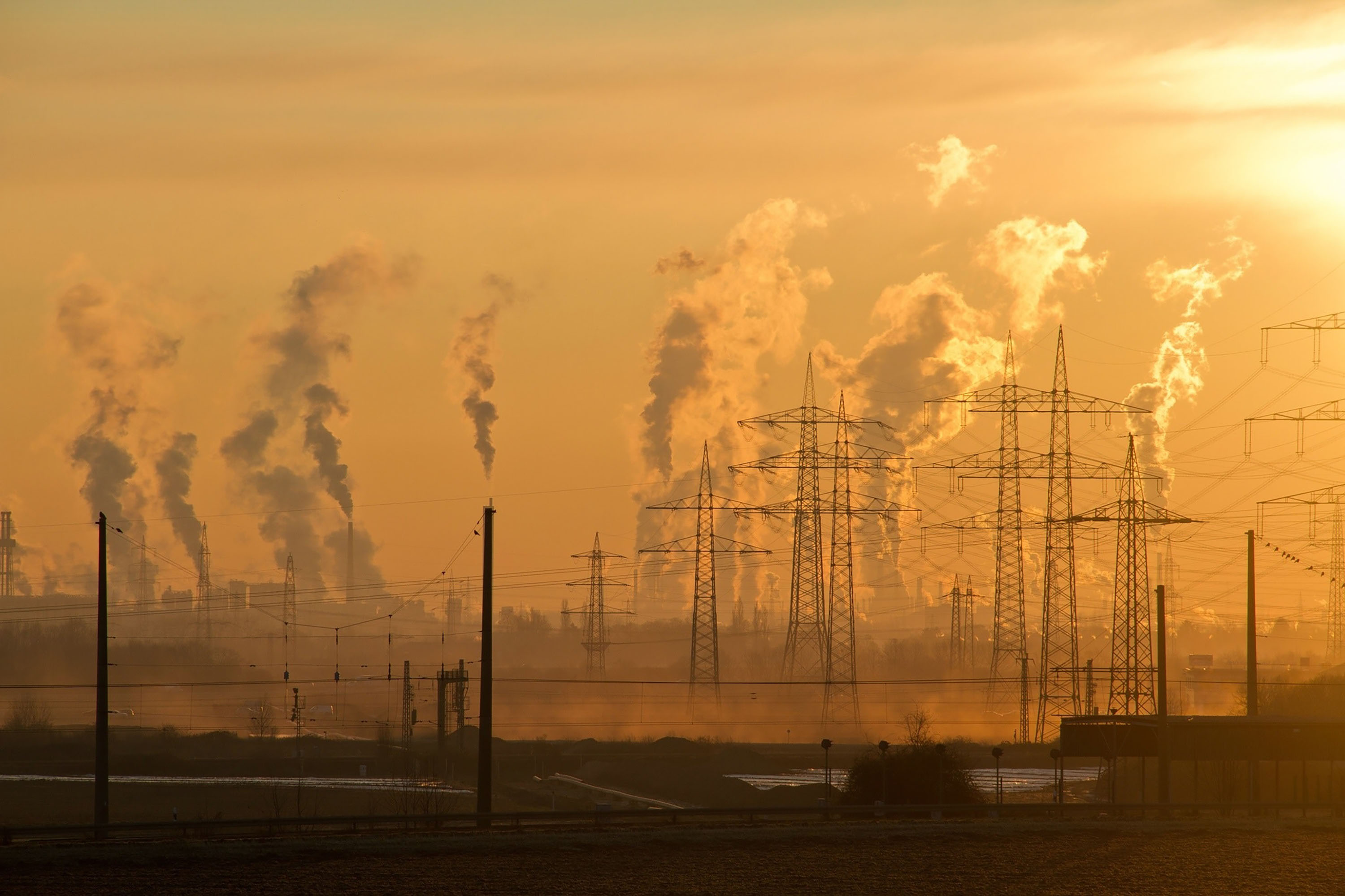 smog filling the air behind wires against an orange sky