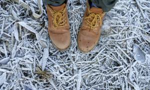 Boots standing on frosty winter ground.