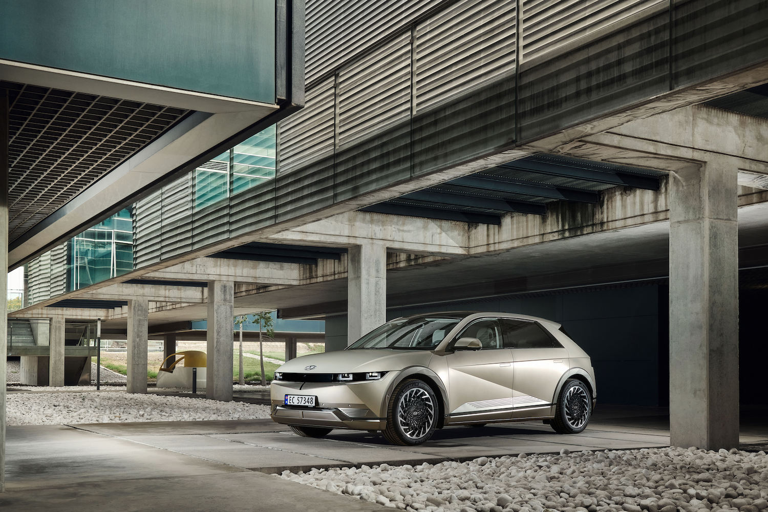 Hyundai Ionic 5 parked in a parking structure with concrete walls and large windows on concrete.