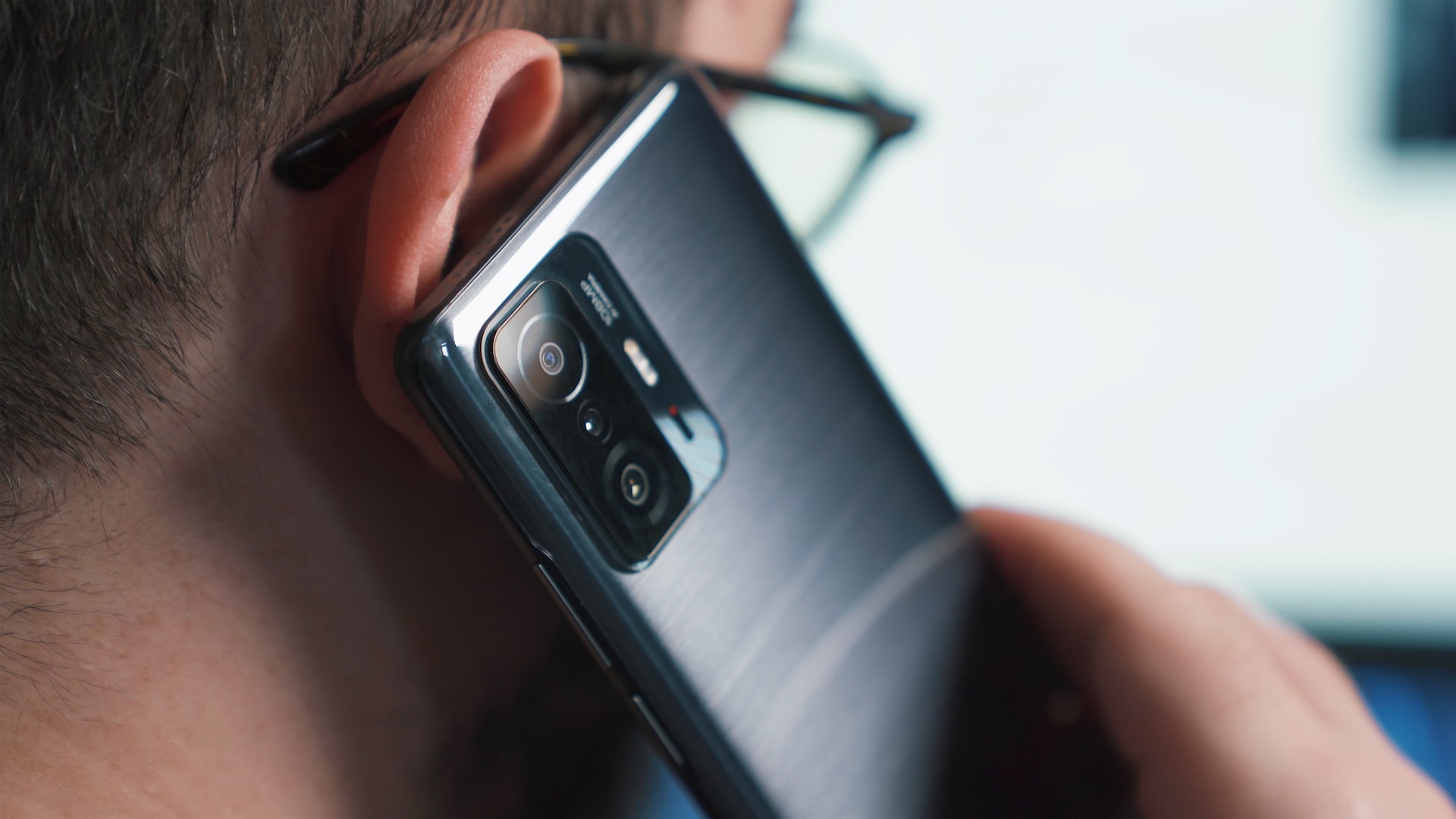 Tight closeup of a man talking on a smartphone.