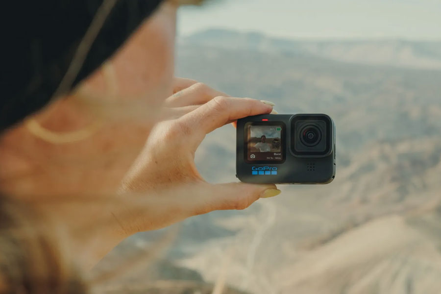 Woman taking selfie with GoPro Hero11 Black Action Camera.