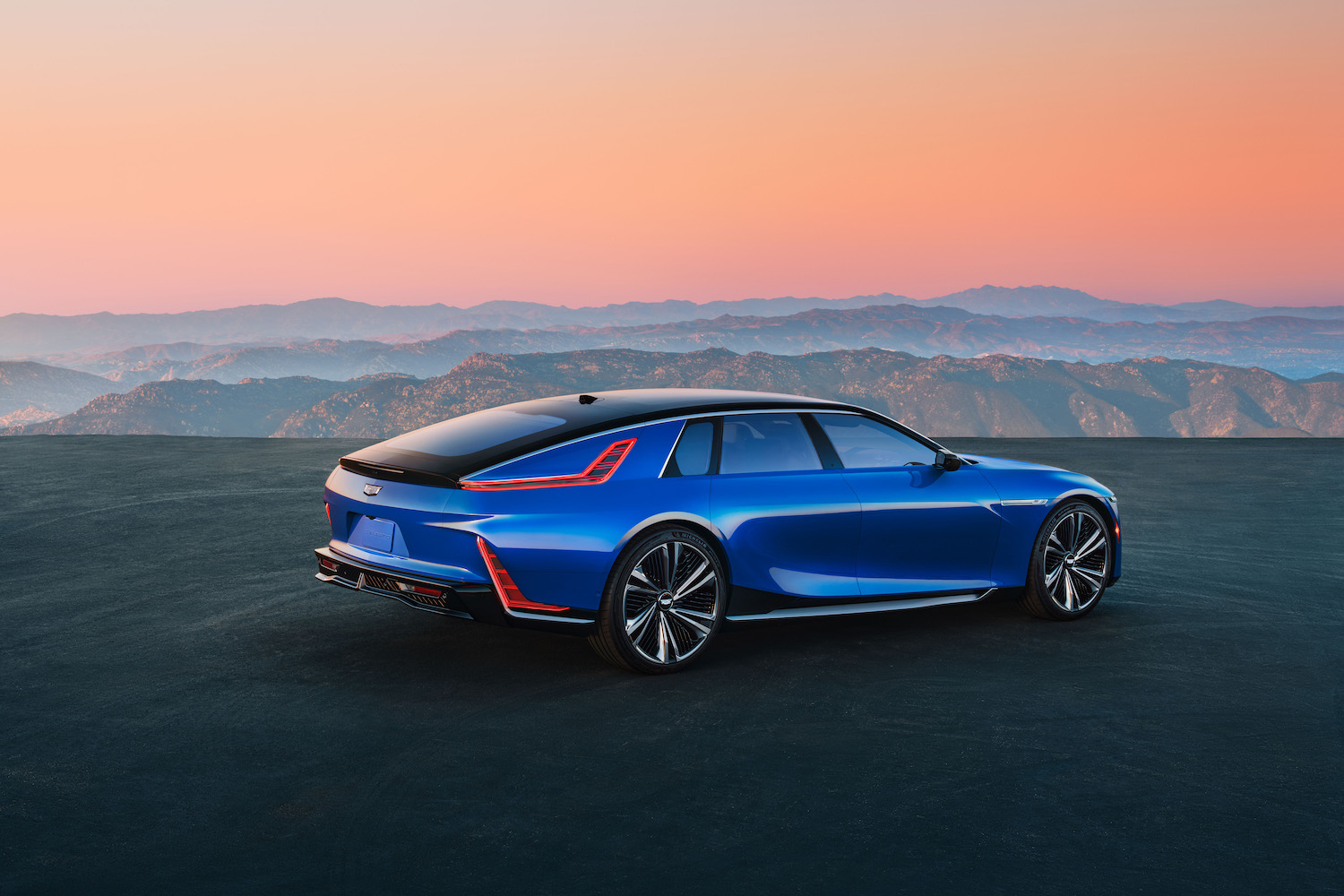 Cadillac Celestiq rear end angle from passenger's side in front of a sunset with mountains in the back.