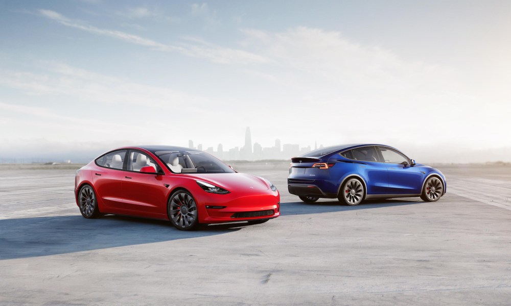 Tesla Model 3 and Model Y parked in front of a city skyline on a runway