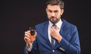 Man holding a bottle of fragrance.