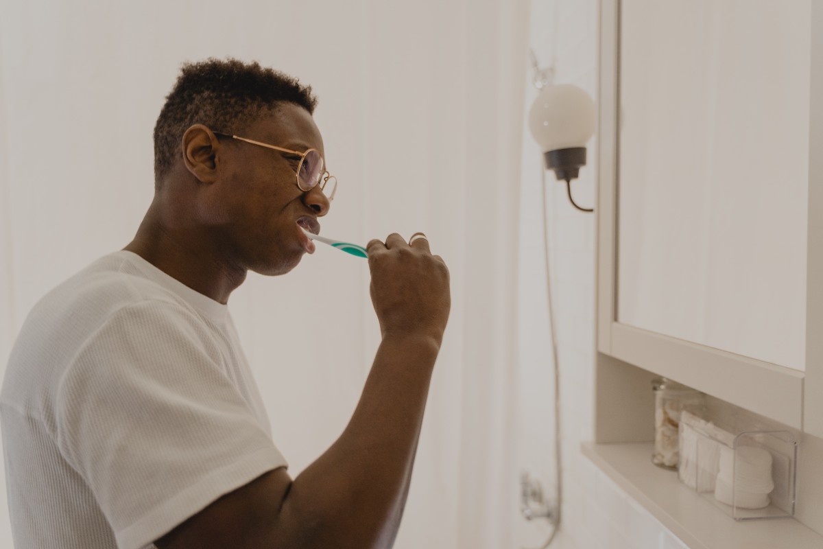 a man brushing his teeth in the bathroom