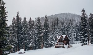 A snowy view with a cabin in the mountains .