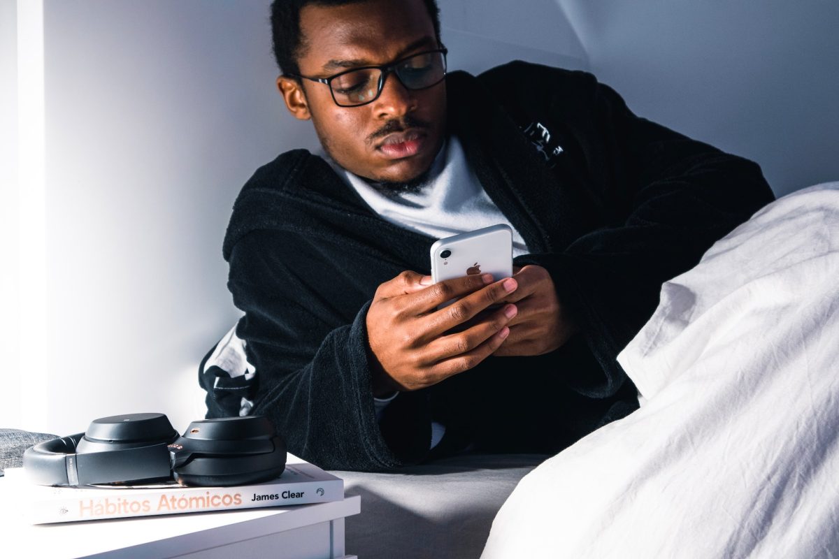 A man getting ready for bed but still on his phone.