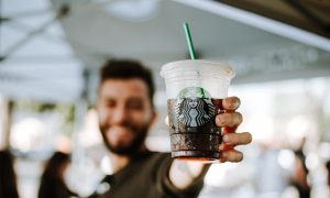 A man holding an iced Starbucks drink.