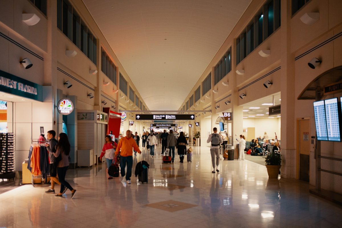 People going into shops inside of an airport.