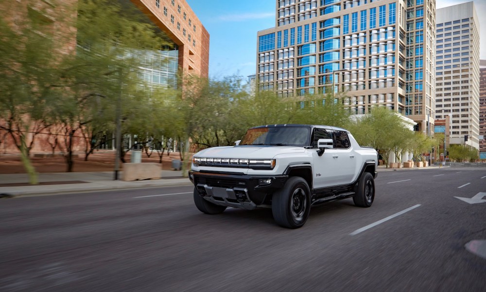 2023 GMC HUMMER EV Edition 1 Pickup front end angle driving down a busy city street.