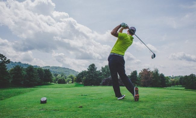 A person hitting a shot on the golf course.