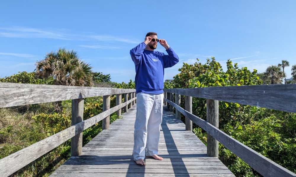 Man in Quicksilver Saturn Collection sweatshirt and pants on boardwalk