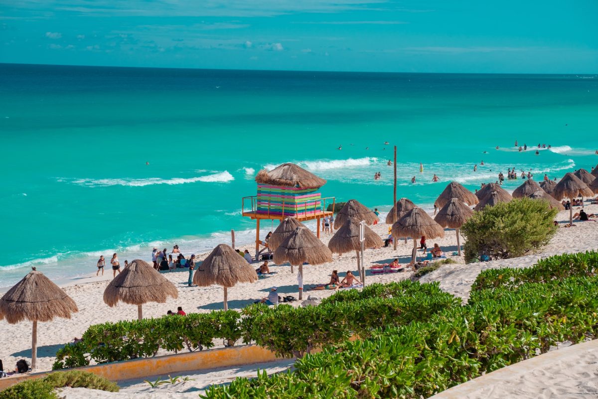 A view of the beach in Cancun with people enjoying themselves.