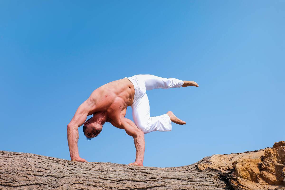 Man doing yoga pose outside.