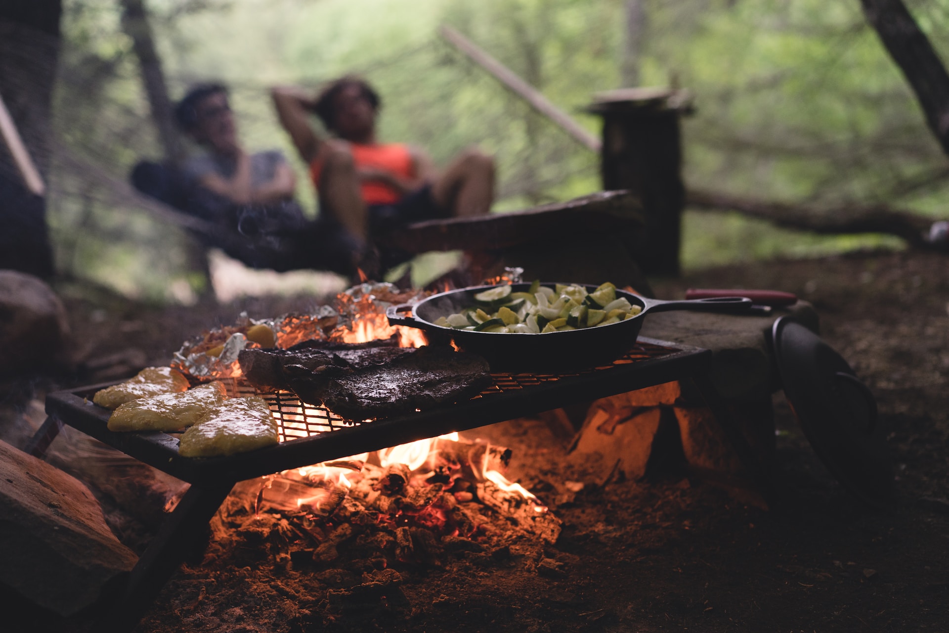 Food cooking over a fire at a campsite