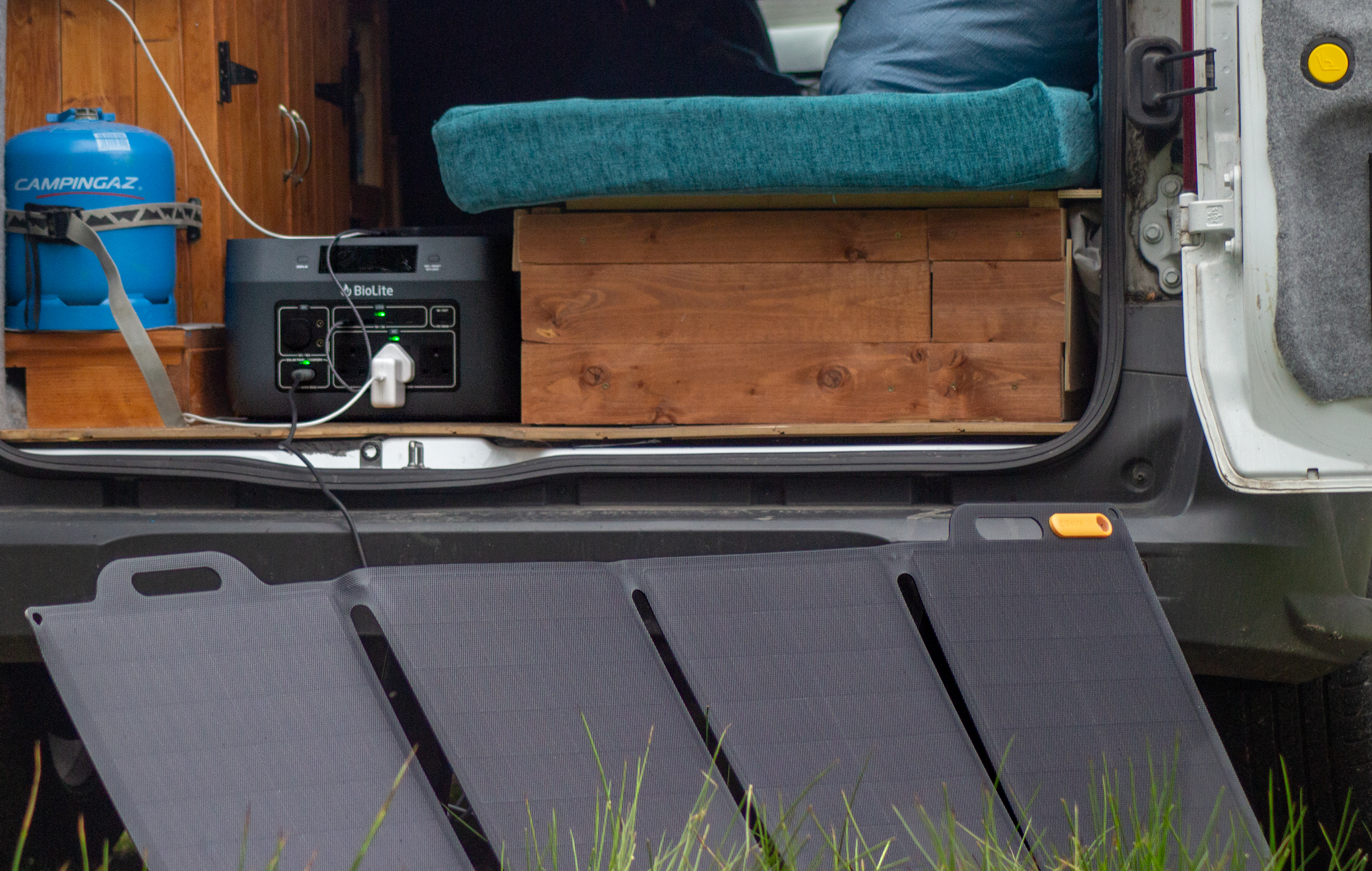 A Biolite basecharge unit and solar panel outside the back of a van