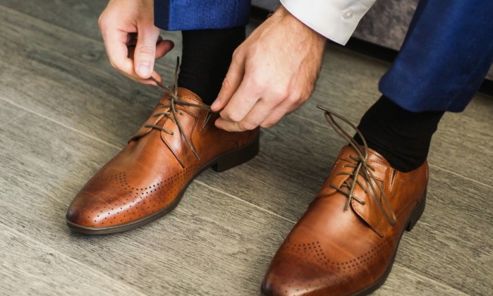 Man tying his brown dress shoes