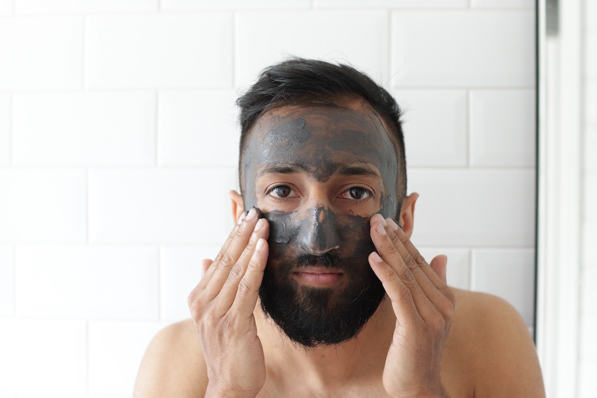 a man with a charcoal face mask